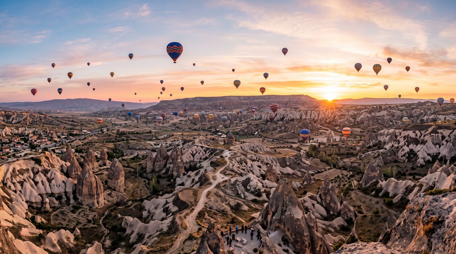 A breathtaking panorama of Cappadocia with balloons at sunrise